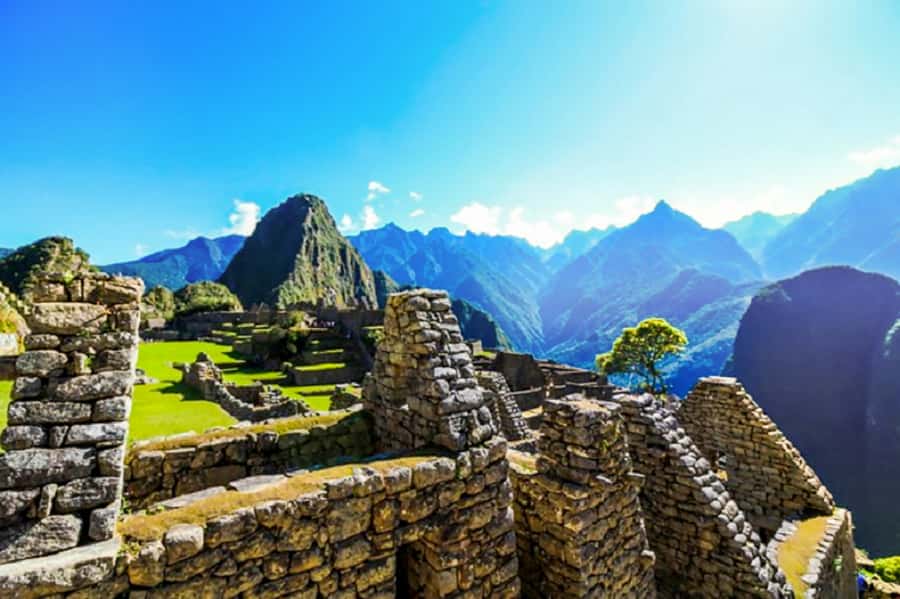 Machu Picchu under morning cloud, with Huayna Picchu behind it